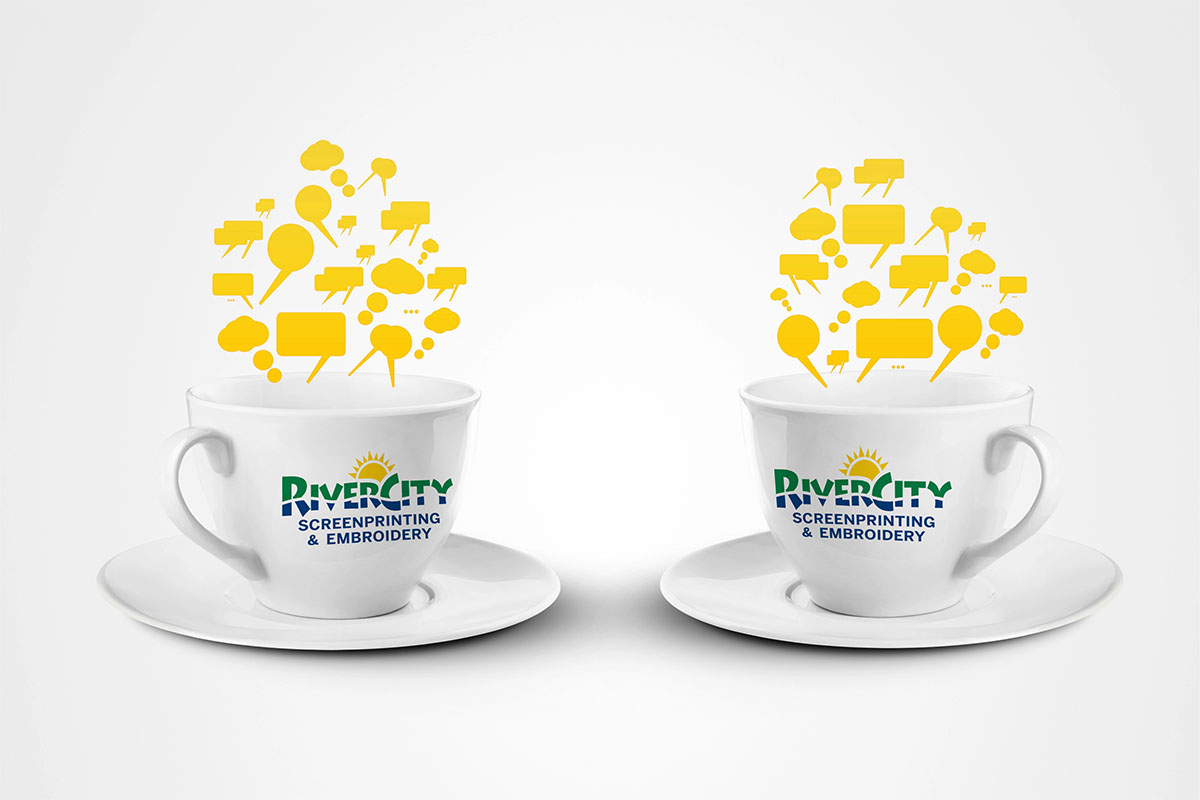 Custom Branded Coffee Mugs Two coffee mugs showcase RiverCity Screenprinting and Embroidery logos.