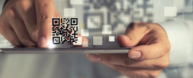 A close-up of a person's hand holding a smartphone, with a QR code displayed prominently on the screen and digital graphics of squares in the background.
