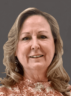 A smiling woman with long, wavy hair, wearing a patterned blouse and earrings, against a neutral gray background.