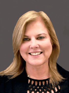 A woman with shoulder-length blonde hair smiles at the camera, wearing a black top with a patterned neckline, set against a dark gray background.