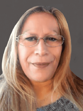A woman with long, light brown hair and glasses smiles at the camera, set against a dark background. She is wearing a gray sweater.